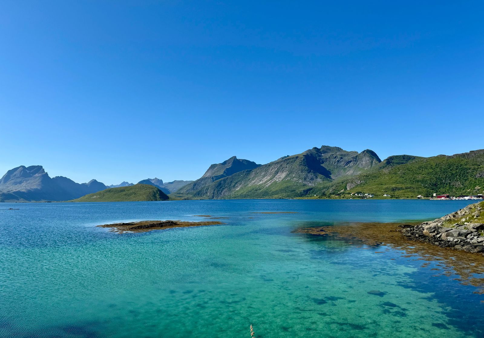 Turquoise water and green mountains on a clear summer day in northern Norway